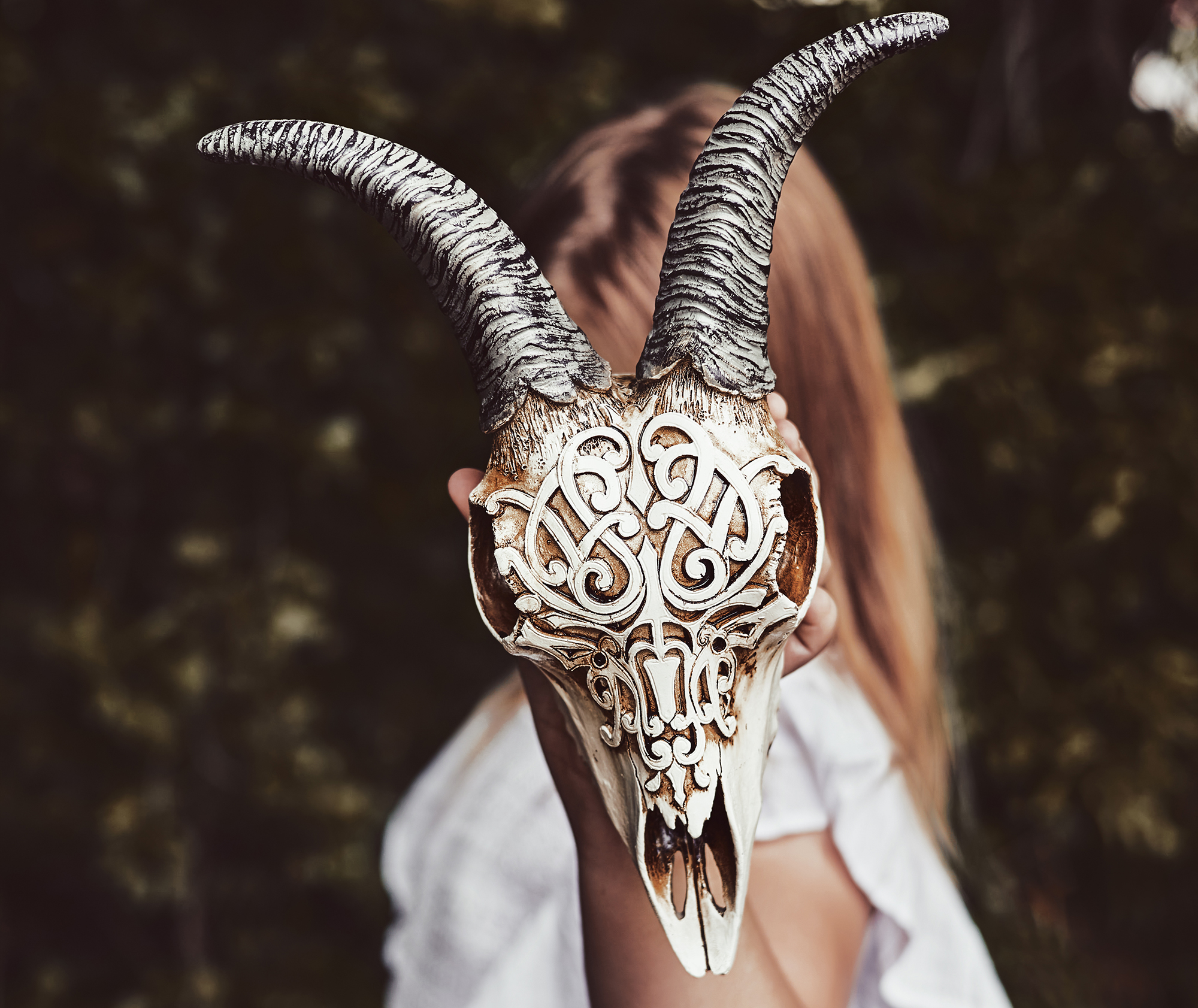 Gothic teenager girl with goat skull, her face is not visible - hidden behind skull. Youth subculture, Day of the Dead, Halloween